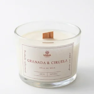 Vela con aroma a granada y ciruela fondo blanco, la mecha es de madera.